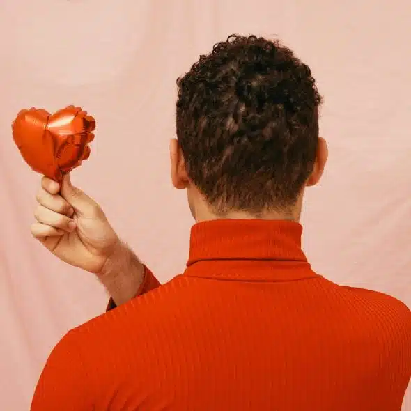 A man holding a balloon heart-shaped