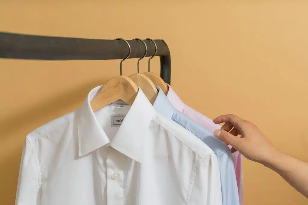 The person is choosing a button up shirt.