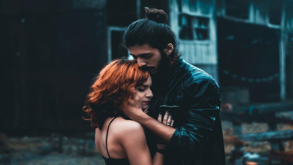 A couple looking sad while hugging.