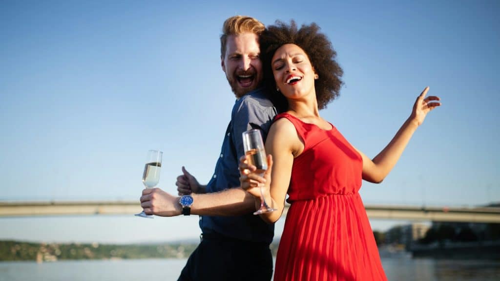 A happy-smiling couple in love dancing and flirting outdoors.