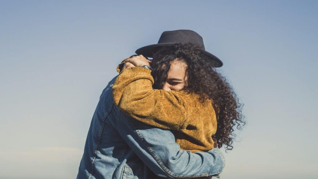 A couple hugging outdoors.