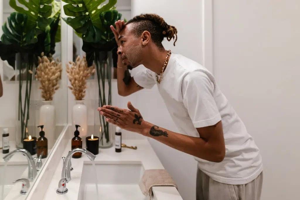 Man in Bathroom Washing Face