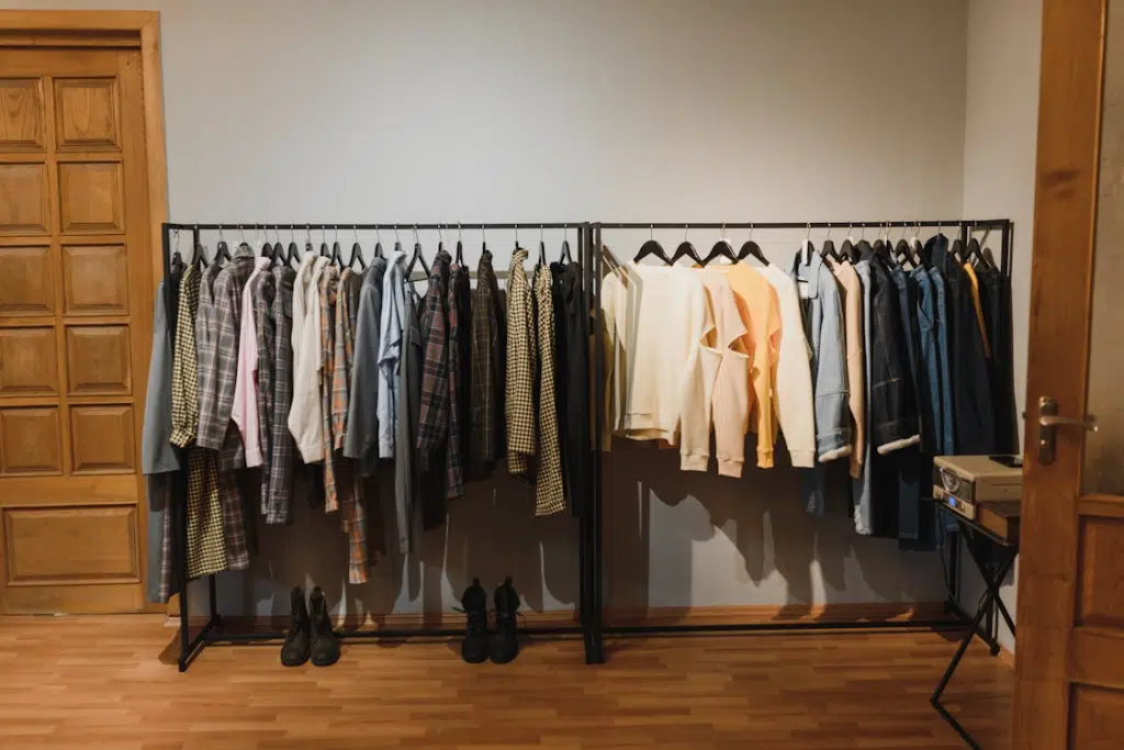 White and Black Clothes Hanging on Black Steel Rack